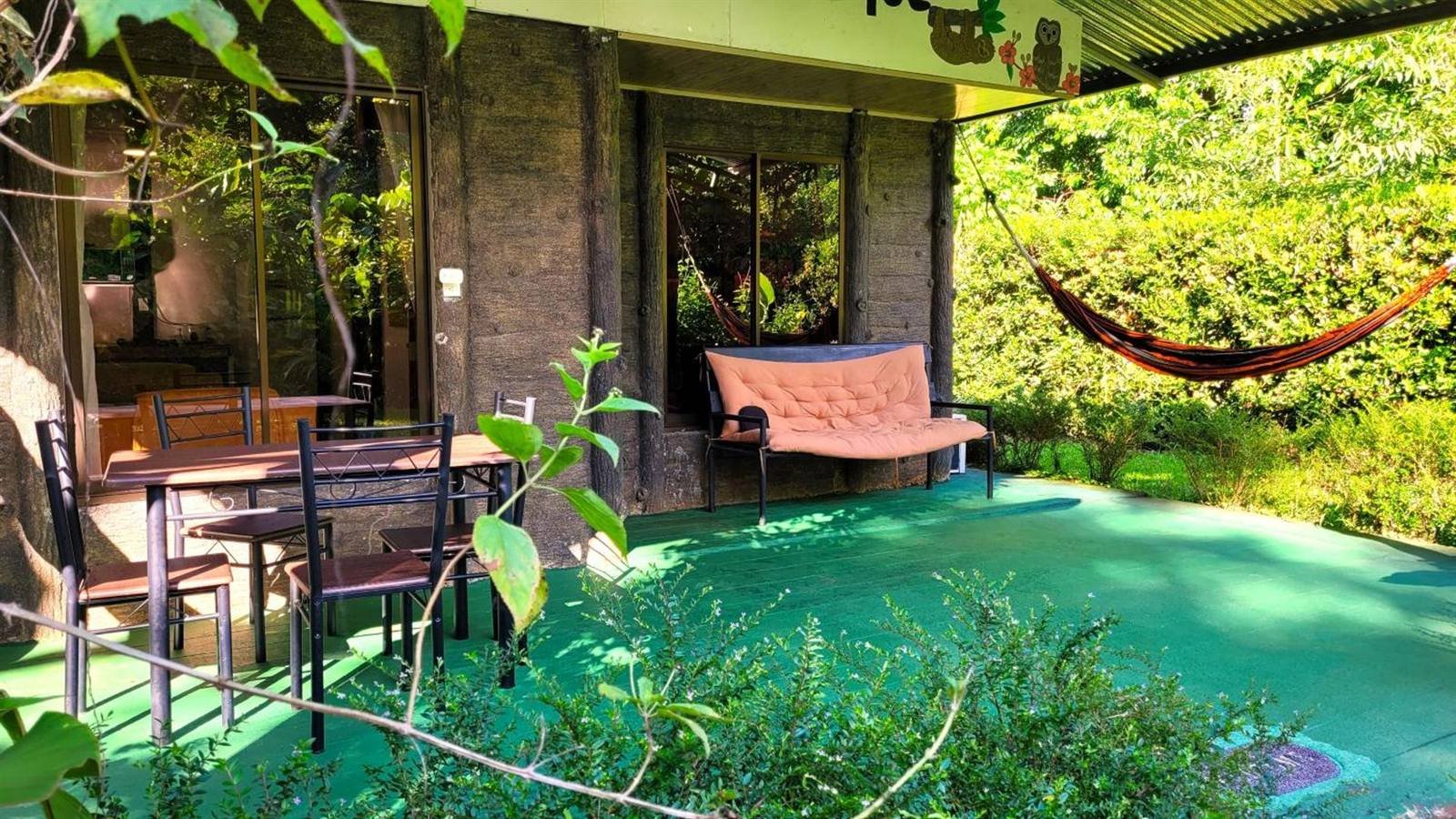 Covered porch with a hammock, table and chairs